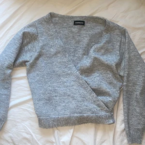 kofta - en grå skön kofta att ha på sig, har två band på sidorna som går att knyta runt midjan 