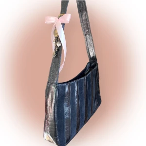 Axelväska  - I toppenskick! Jättesöt väska med fina detaljer. Suede blandat med skinn(?) Vet ej om det är äkta skinn. Made in Italy ⚠️ Rosetten är knuten så att inte ringen där alla berlocker är fästa fladdrar runt. Det går att ta av rosetten och berlockerna! 