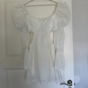 Vit klänning med puffärm - Säljer denna helt nya klänningen från boohoo med prislapp kvar. Den är långärmad med puffärm och har även cut outs på sidorna. Se sista bilden för en bild med samma klänning fast blå för att se hur modellen ser ut på. Strl 34 och säljer för 150kr