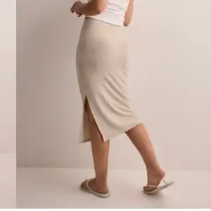  Superfin beige kjol med slits. Säljer då jag ej använder den. Använd endast ett fåtal gånger, så den är som ny.  Kan skicka egna bilder vid intresse💗