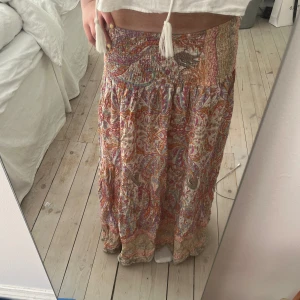 Långkjol - Skit fin lång kjol med coola mönster! Det står onesize i men skulle säga att det är xs/s, hade säkert funkat på M med. 