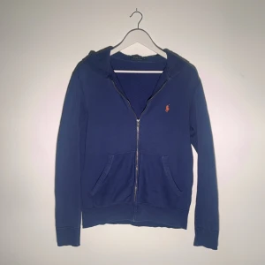 Ralph Lauren Full zip  - Skick: 7/10  Storlek: S  Färg: Blå  Defekter som visas på sista bilden är vid armbågarna, alltså på armbågarna är det lite små hål men märks inte mycket. 