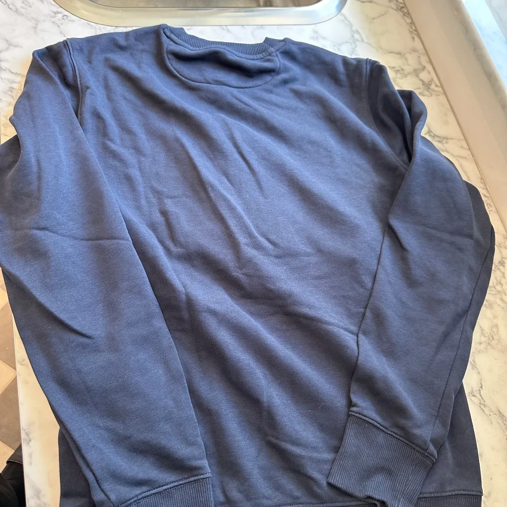 En mörkblå Gant tröja i storlek S med ett stort gant tryck i mitten. Tröjan är av de mjukare materialen och är lätt att röra sig i. Passformen är ganska tajt runt ärmarna men lösare i mitten men perfekt runt midjan. Tröjan har endast använts 5-10 ggr. Hoodies.