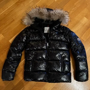 Moncler jacka junior - Moncler jacka junior i storlek 11-12 år, ca stl 152-158, med äkta päls och QR-kod innanför jackan.