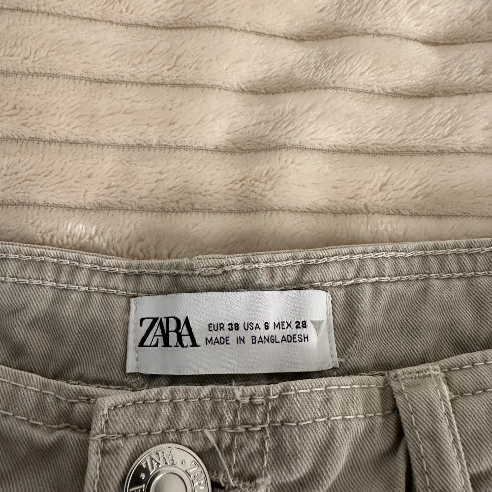 Cargobyxor från Zara i en fin beige/grå färg. Storlek 38 och använd cirka 5 gånger därav inga defekter. 🤍. Jeans & Byxor.