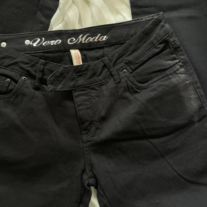 Svarta low waist jeans från Vero Moda  - Dekoration på bakfickorna, se bild 2.  Storlek 40  Från Vero Moda  Sällan använda, säljer då de inte passar.  :) 
