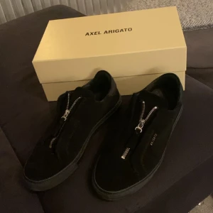 Axel Arigato Clean 90 Zip Sneaker Black - Nyskick 10/10. Inköpta sommaren 2023 för 2500kr, endast testade hemma har legat i kartongen sen dess pga för små. Storlek 42