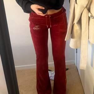 Röda juicy byxor med fickor samt rhinestone text där bak Storlek xs