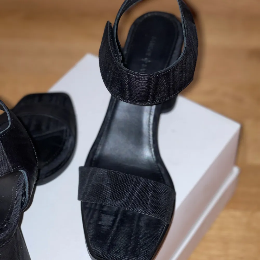 Uppgradera din skogarderob med dessa eleganta sandaler. Dessa är svarta med ett räfflat tyg! Sandalerna har använts två gånger och är i mycket bra skick. De är i storlek 38 ovh är normala i storleken. Vi tar ej emot retur!. Skor.