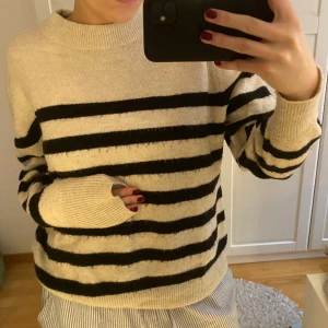 Randig stickad tröja  - Beige svart randig stickad tröja från Hm! Anvädn men fortfraande i bra skick!
