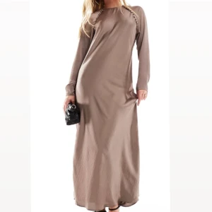 Satin Maxiklänning - En söt maxiklänning i mockabrun färg, storlek EU 34. Klänningen är köpt från Asos men är liten för mig och returtiden hann passera innan jag returnera klänningen. Därav helt ny . Köpt för 629kr och säljer för 600kr. Kan mötas upp i Växjö🩷