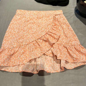 Blommig kjol - En söt kjol i storlek 143/140 men kan lätt passa upp till två storlekar till då den har resor i midjan 