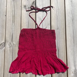 Supersöt rosa/röd topp - En jättefin sommartopp som passar till det mesta. Finns ingen lapp på den men passar storlek xs/s. Aldrig använd då den inte passar. Väldig stretchig och två band som man knyter runt nacken