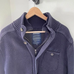 Sebago Cardigan - Grymt snygg Cardigan/tröja från Sebago av bästa kvalitet. St XL, passar L. Perfekt till höst eller sommarkvällar. Den är nyskick och kostar ca 1200kr ny. Har extremt svårt att hitta den online så det är ett riktigt kap. 