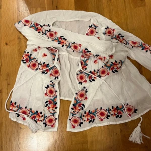 Super söt bolero/ blus  - Jättesöt och blommig med knytning där fram, aldrig använd!