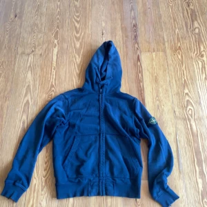 Svart Stone Island Zip hoodie  - Väldigt skön och cool, tyvärr 3 tråkiga skavanker som syns på bild 3. Sitter som en M. Säljes då den ej passar