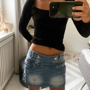 Lågmidjad jeanskjol - Supersöt jeanskjol med massa söta detaljer som är perfekt nu på sommaren. Midjemått 40cm och längd 30 cm. 
