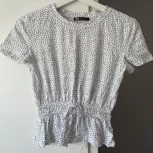 Prickig topp - Prickig topp från Zara i storlek S. Har en rosett i midjan. Liten i storlek, är mer som en XS. 