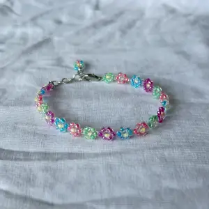 Somrigt armband med blommor i olika färger. Pärlat för hand. 