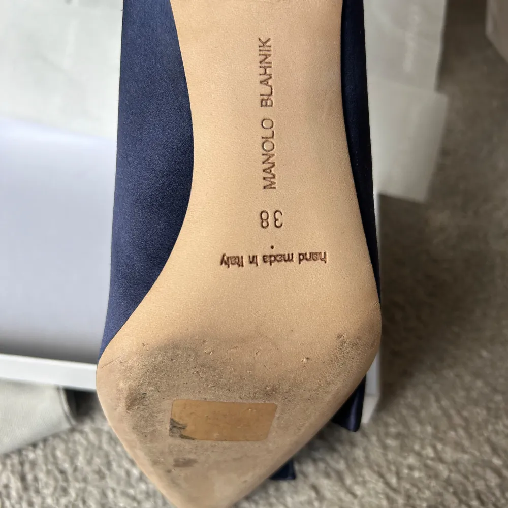 Äkta eleganta mörkblå pumps från Manolo Blahnik med spetsig tå och rosett framtill. Skorna är i satin och 9 centimerters klack. Använda en gång, lite smutsiga på sulan. Dustbag och skolåga tillhör. Köparen står för frakt. NYPRIS 9000. Kengät.