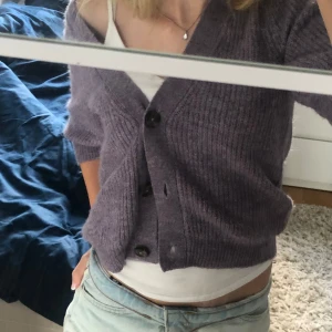 Stickad kofta - Lila stickad kofta med trekvartsärmar. Helt oanvänd, köpte men kom aldrig till användning. Fint till hösten. Stretchiga material