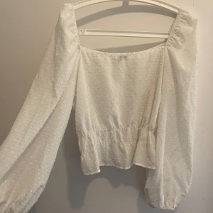 Gina tricot Blus Vit - Gina tricot Blus i Vitt skir  Superfin med lite ballongärm, håller sig uppe på axlarna.  Storlek: 40