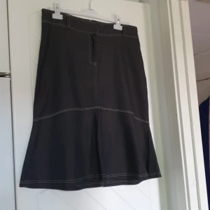 Svart jeanskjol  - Svart, utsvängd jeanskjol.  Storlek L. 40/42 