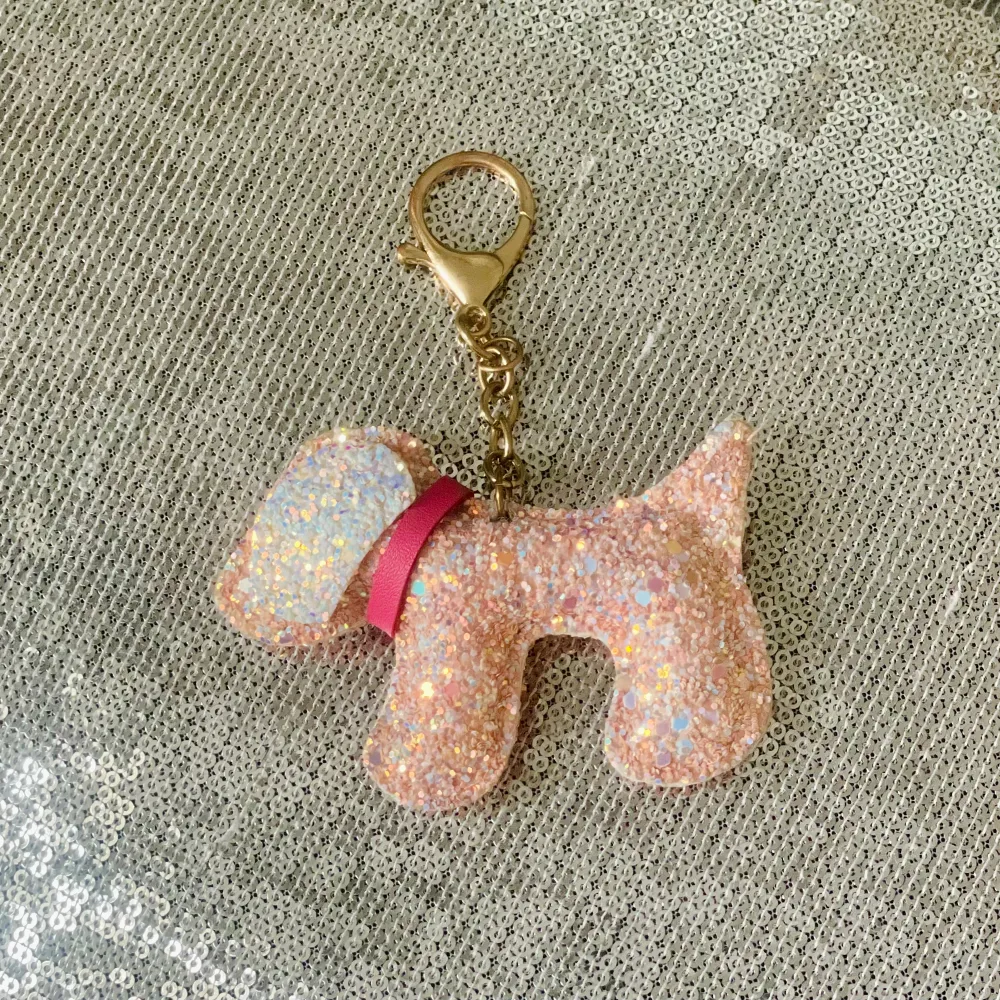 Vacker glittrig nyckelring med hund i rosa/vitt. Snygg på väskan som extra detalj eller nycklarna. Accessoarer.