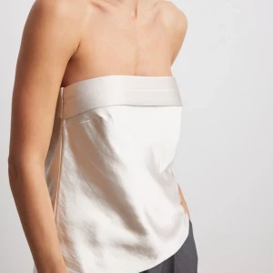Bandeau-topp i satin XS  - Säljer denna så fina toppen ifrån NA-KD i storlek XS! Helt slutsåld och aldrig använd, prislapp finns kvar. Nypris är 349kr 🫶🏼 säljer även i svart. 