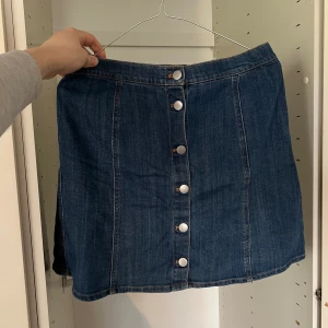 Jeanskjol - Jeanskjol med knäppning fram. 