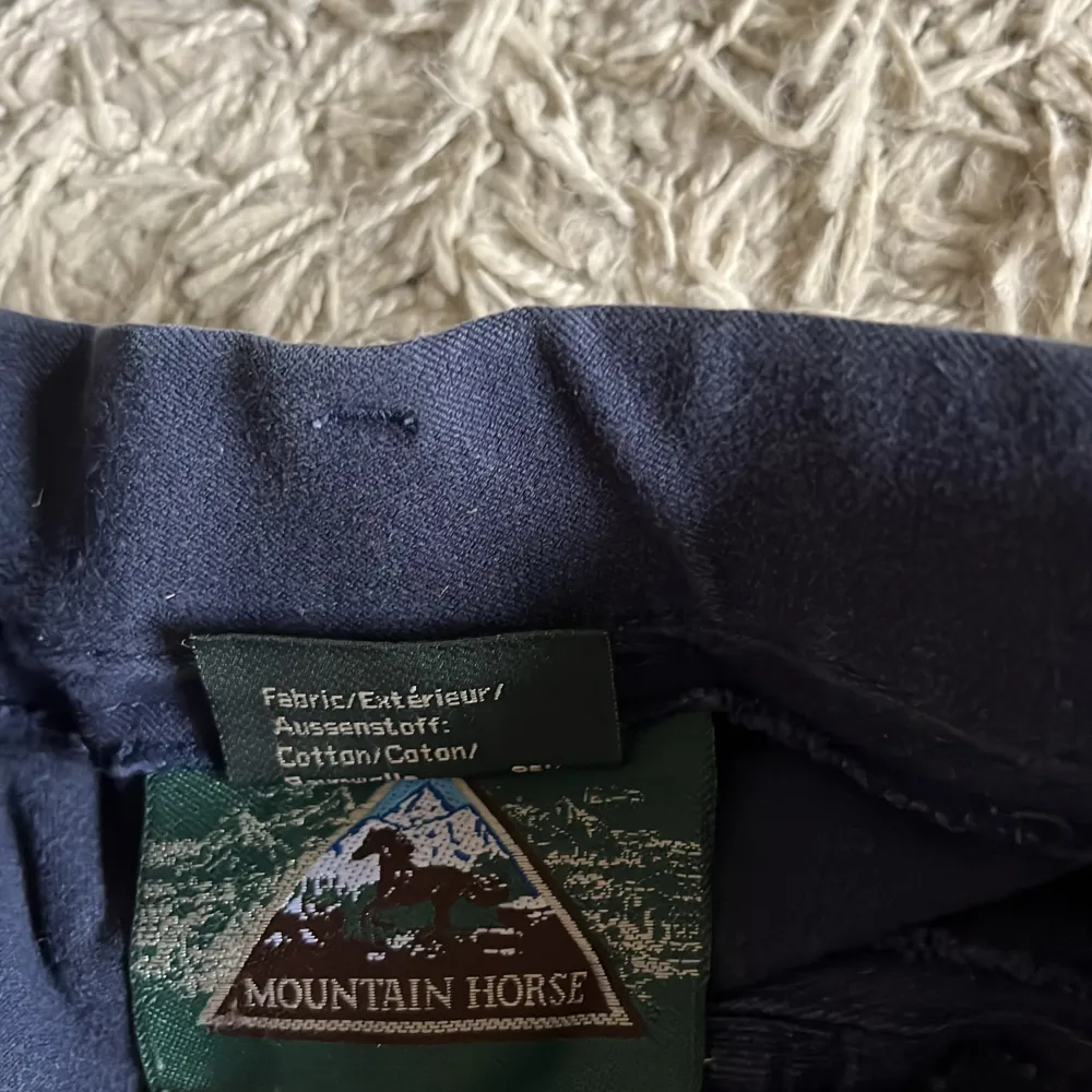 Marinblå ridbyxor från Mountain horse! Fint skick. Äldre modell. Fickor framtill. Kardborreband längst ned vid benen. Skodda i knäna o bak. Pris diskuterbart ❤️. Farkut & Housut.