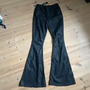 Svarta bootcut byxor i fejkläder material, från bohoo helt nya med taggen kvar, stl 34