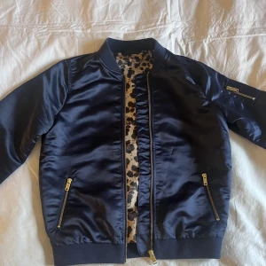 Bomberjacka  - Mörkblå bomberjacka i nyskick, leopardmönstrat innertyg och guldiga detaljer. Från Heidi Klums kollektion med esmara. Kolla gärna in våra andra annonser!