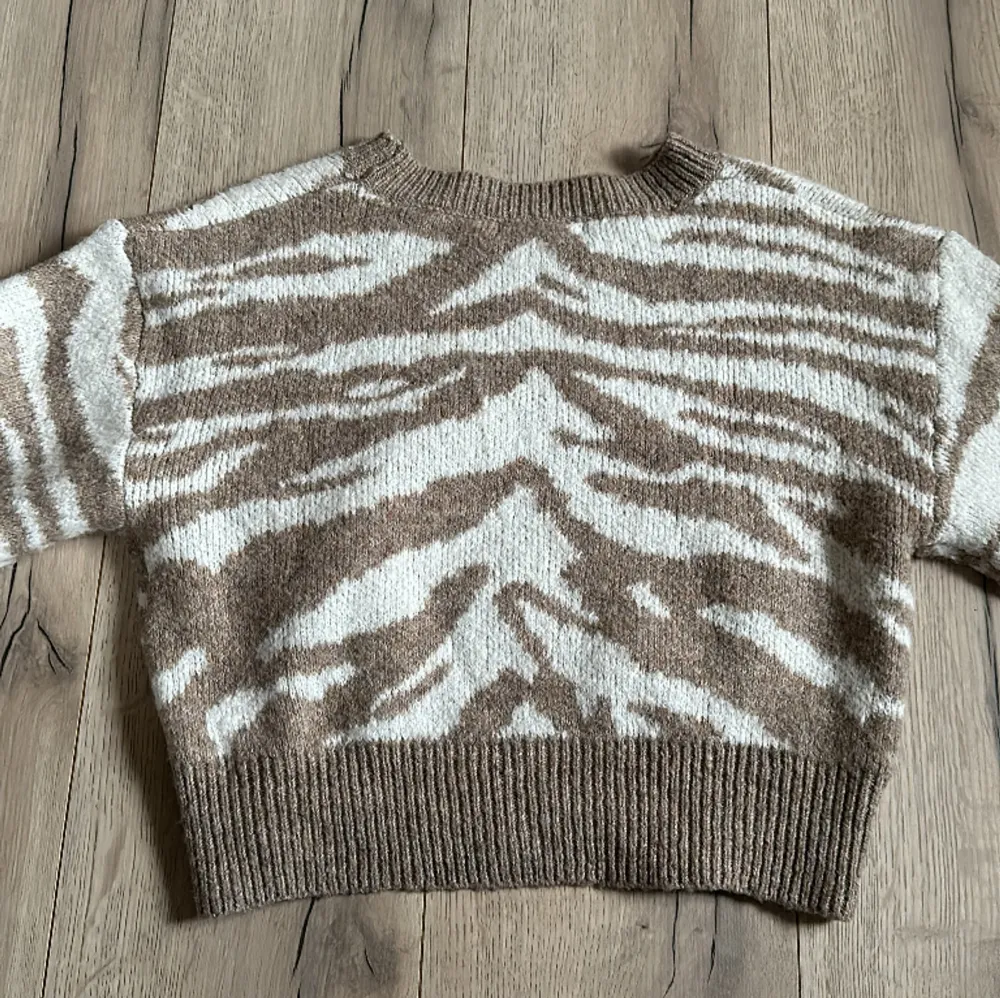 Tiger/zebra randig stickad tröja i vit och beige färg. Varm, skön och i bra skick!. Tröjor & Koftor.