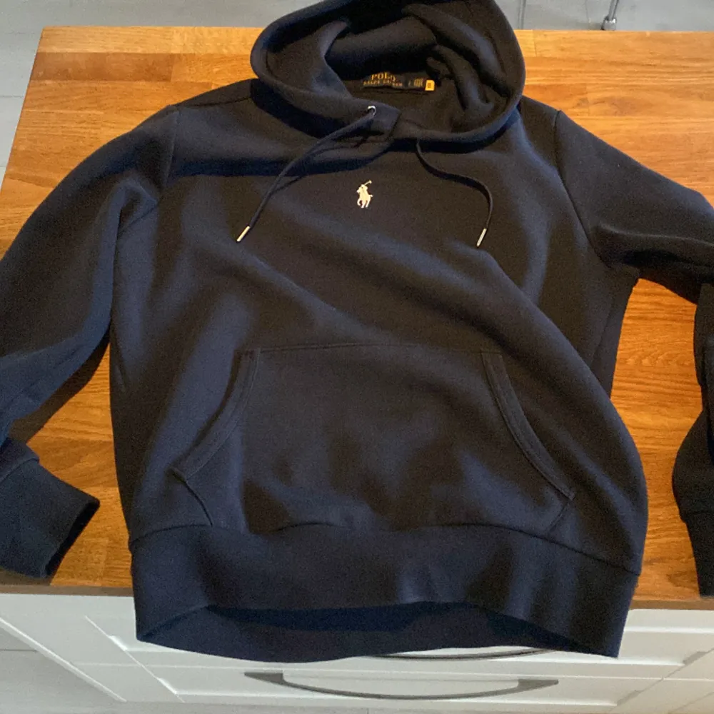 Ralph lauren hoodie, marinblå  Köpt och nypris för 1999kr Använd ett fåtal gånger.  Finns inget fel på den, de ända är att i sidan vid midjan har den blivit nopprig men syns knappt. För mer frågor kontakta gärna.  *Pris går att diskutera*. Tröjor & Koftor.