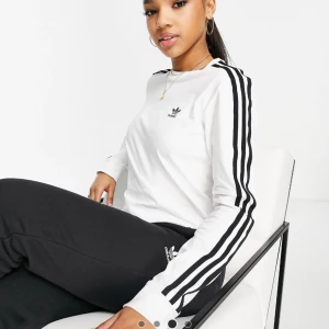 Top adidas - Säljer helt ny top från adidas eftersom returdatumet har passerat.  adidas Originals - Vit t-shirt med länga ärmar och tre ränder