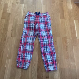 Pyjamasbyxor - Röda pyjamasbyxor med en guldig tråd och rosett. Säljer pågrund av att de är för små. Dem är i flanell och bra skick💖Säljer för 60kr plus frakt. Skriv innan ni köper