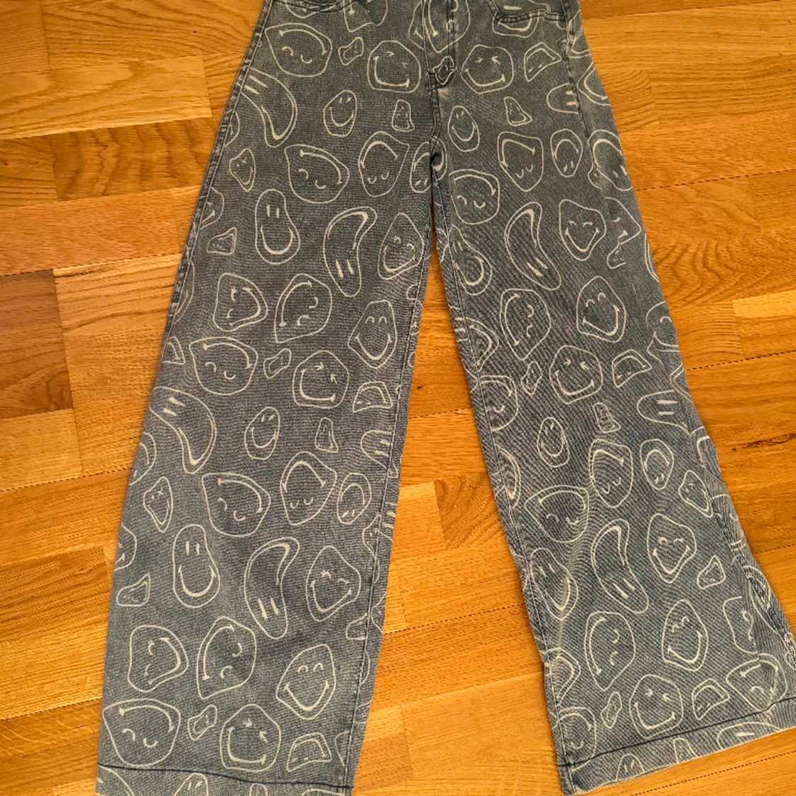 Ett par blåa jeans med smileys på 