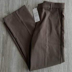 Kostymbyxor - Brun/gråa kostymbyxor från Gina Tricot! Färgen heter Falcon. Endast testade därav är lappen kvar! Fraktavgift tillkommer 🌸 nypris 400kr.