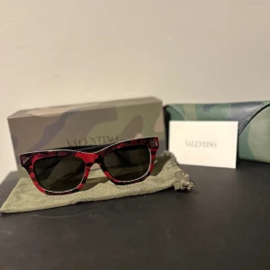 Valentino solglasögon - Säljer nu ett par Valentino camouflage wayfarer solglasögon. De är i mycket bra skick då de knappt är använda. Kostar runt 2000kr nya. Äkta, allt finns med. Hör av er vid intresse. Pris kan diskuteras