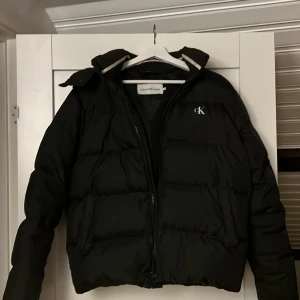 Calvin Klein dun jacka  - Det är en vinterjacka Calvin klein puffer i nyskick.   Vuxen Storlek : medium. Jag säljer den därför att jag köpte en ny och inte andvänder den.  Den har inga skador, och Den är köpt på design only i nordstan. Priset kan diskuteras vid snabb affär! 