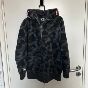 BAPE Hoodie - Fin BAPE Hoodie i storlek S  Anledningen till att jag säljer tröjan är att den var för stor i storleken köpte den av en vän för ett tag sen för 2000kr men har inte använt den inte passa. Priset går att ändra på vid snabb affär svarar ej på scam bud