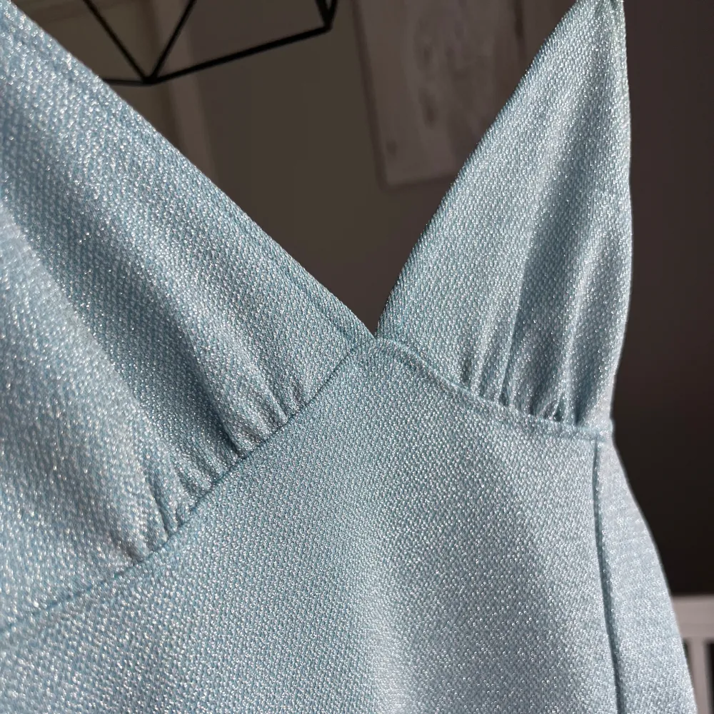 Glittrig blå klänning från H&M, använd 1 gång! . Klänningar.