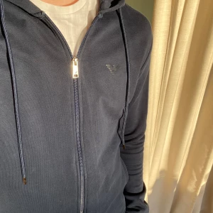 Armani hoodie - Säljer nu min feta mörkblåa Armani hoodie. Skicket är riktigt bra utan några hål eller fläckar överhuvud taget eftersom jag har andhämtning den så få gånger. Nypriset ligger nog någonstans runt 1200kr och mitt pris är 599kr. Skriv för bilder/frågor😁🤝