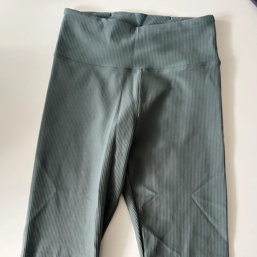 Ribbade träningstights från Röhnisch i färgen grå/grön. Helt oanvända. Mjuka i tyget och sitter bra. Storlek XS men är som en S. . Jeans & Byxor.