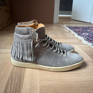 Saint Laurent herrskor - Saint Laurent sneakers för män i jättefint skick i storlek 42,5. Passar 42 och 43.  Använda vid få tillfällen så skicket är väldigt bra. Autentiska med äkthetsbevis i form av kod inuti skon. Priset går att diskuteras vid en snabb affär.