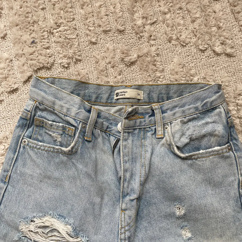 Ljusblåa jeans från Gina tricot med hål på. Västligt snygga jeans i storlek 34. Dom är väl använda men det syns kannapt 🫶🏼. Jeans & Byxor.