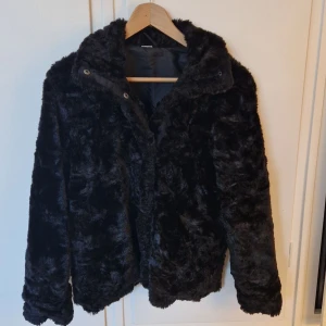 Populär pälsjacka  - En pälsjacka i svart som knappt är använd . Det är ”knappar” och inte dragkedja, vet dock inte vart den är ifrån kan vara zara . Och såklart är den inte i äkta päls , så rik är jag inte men skön är den iallafall ;) 