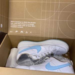 Vita Nike air force 1 sneakers med ljusblå logga och sula! Använda men i bra skick, storlek 39 Nypris 1600:- Pris kan diskuteras vid snabb affär 