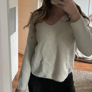 Vit stickad tröja - Stickad tröja från HM med v-ringning. Tröjan är använd en del men inga större defekter